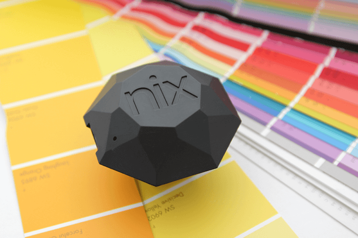 A fan deck is spread out with a Nix Pro sitting on top of a yellow swatch