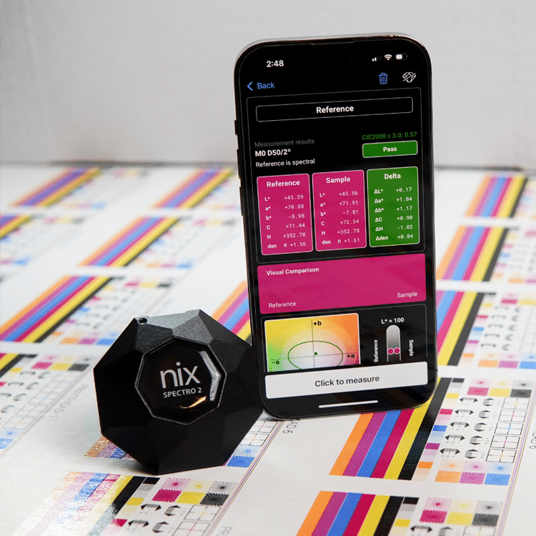 Nix Spectro 2 color measurement device next to a smartphone displaying color reference data and measurements.